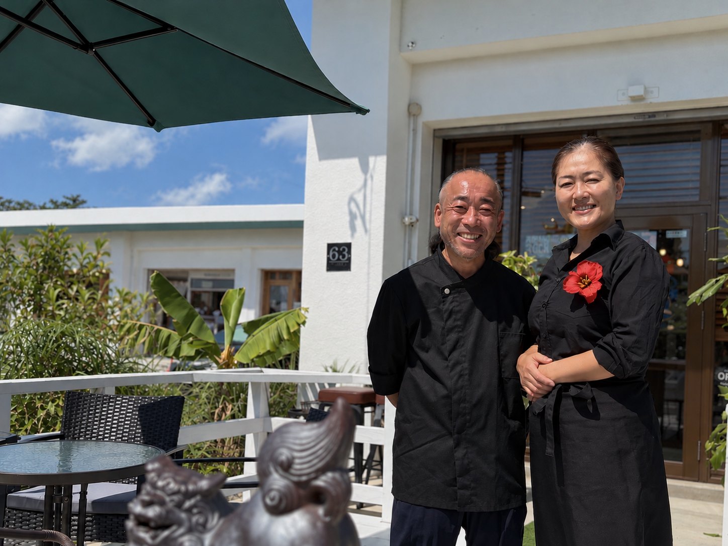 店舗前でお客様を迎えるシェフとソムリエの夫婦